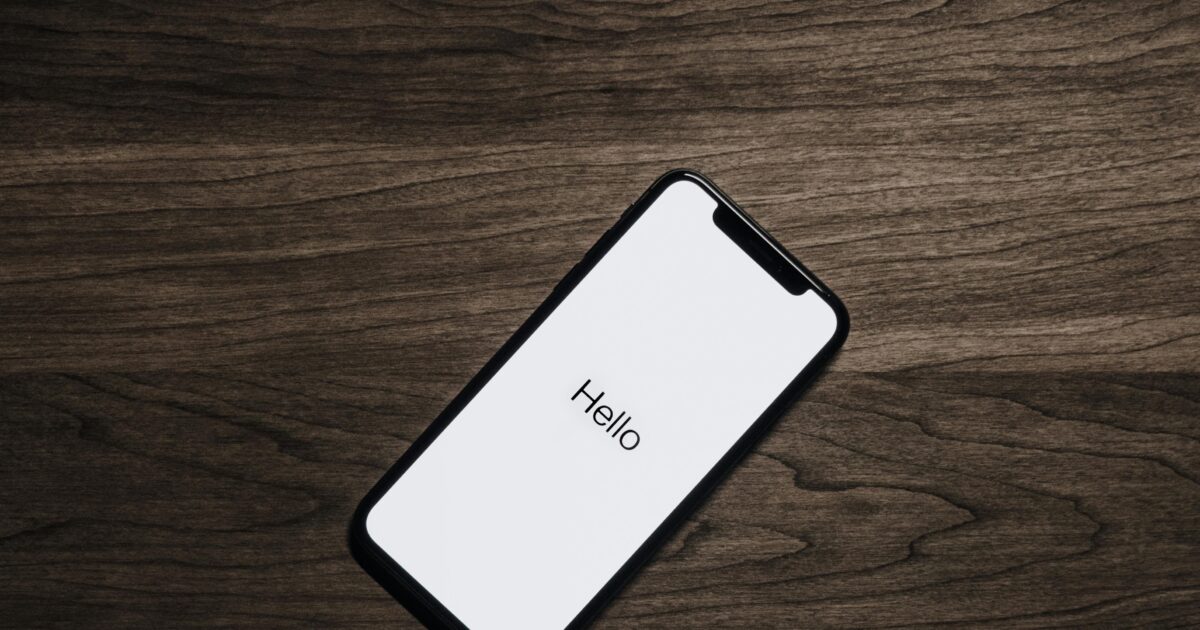A smartphone displaying 'Hello' on a wooden surface, showcasing modern technology.