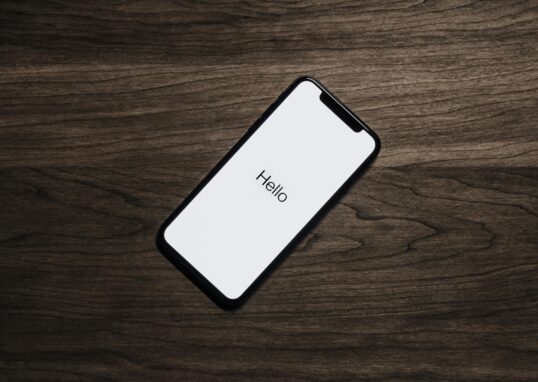 A smartphone displaying 'Hello' on a wooden surface, showcasing modern technology.